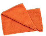 Imagem: Fotografia. Um guardanapo de cor laranja, dobrado.  Fim da imagem.