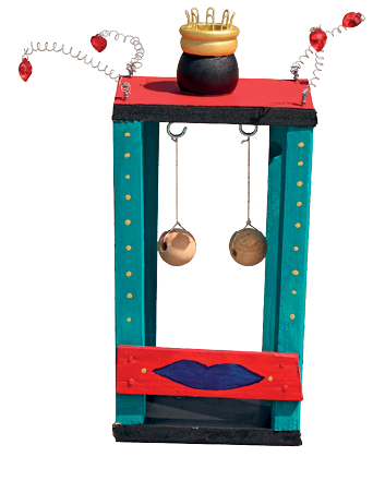 Imagem: Fotografia. Objeto com o formato de duas hastes na vertical de cor azul-claro, na parte horizontal em vermelho e parte inferior em vermelho e pintura de boca de cor azul-escuro. Na parte superior, objeto em ferro na vertical com parte inferior redonda em bege. Na parte superior, quatro fios em espiral com parte superior em vermelho e ao centro, forma arredondada em preto e parte superior dourada.  Fim da imagem.