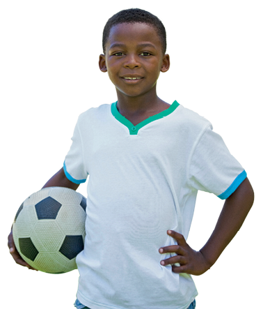 Imagem: Fotografia. Um menino visto da cintura para cima, segurando a bola de futebol na mão esquerda dele e mão direita na cintura, olhando para frente sorrindo. Ele tem pele negra, cabelos pretos, com camiseta branca, com detalhes em gola em verde e nas mangas em azul-claro.  Fim da imagem.