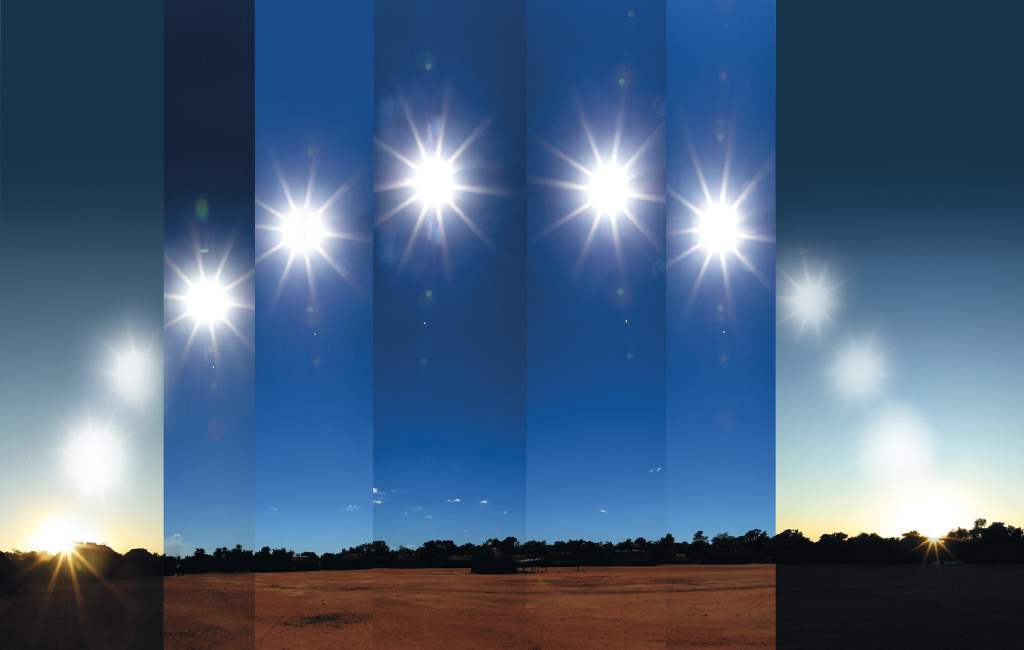 Imagem: Fotografia. Sete fases diferentes de sol em local com solo de cor marrom. Ao fundo, sombra em marrom de local com vegetação e na parte superior, céu de cor azul-claro. Da esquerda para à direita : sol de cor amarela com raios solares grandes, para o alto, céu em azul-escuro. Na segunda fase, o sol vai para cima. Na terceira fase, sol mais alto e céu mais claro. Na quarta fase, sol no alto com céu azul mais escuro. Na quinta fase, sol mais baixo, com céu azul. Na sexta fase, em céu azul-claro e na sétima fase, céu de cor azul-escuro com três imagens de sol mais claro.  Fim da imagem.