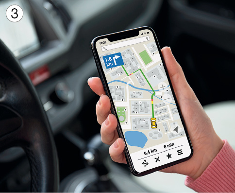 Imagem: Fotografia 3. Dentro de um carro, com mão direita de pele clara, roupa rosa, segurando celular preto com mapa na tela. Na parte superior, à esquerda, 1,8 Km e na parte inferior, 6,4 Km – 6m.  Fim da imagem.