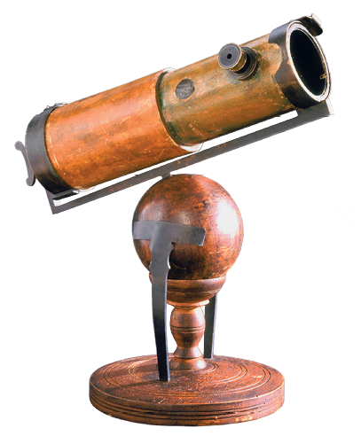 Imagem: Fotografia. Um telescópio de madeira, com formato tubular na horizontal de cor marrom-claro e detalhe em marrom-escuro. Na parte inferior, base arredondada, sobre haste em parte inferior arredondada.  Fim da imagem.