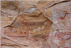 Imagem: Fotografia. Rocha de cor bege-claro, com pinturas de cor vermelha e branco ao centro, de animais na vertical, um na parte superior quadrúpede, com o corpo para à direita. Mais abaixo, outro animal maior virado para à esquerda, quadrúpede. Na parte inferior, dois seres em brancos bípedes.  Fim da imagem.