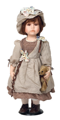 Imagem: Fotografia. Boneca com chapéu bege, cabelo castanho claro e curto, olhos castanhos, vestido marrom e bege e botas marrons. Ela está segurando um urso de pelúcia na mão esquerda. Fim da imagem.