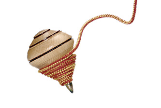 Imagem: Fotografia. Um pião de madeira com uma corda enrolada na base.  Fim da imagem.