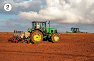 Imagem: Fotografia. 2: Trator com arado para roça passando pela terra. Fim da imagem.