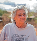 Imagem: Fotografia. Mulher de cabelo curto grisalho, vestindo camiseta branca. Fim da imagem.