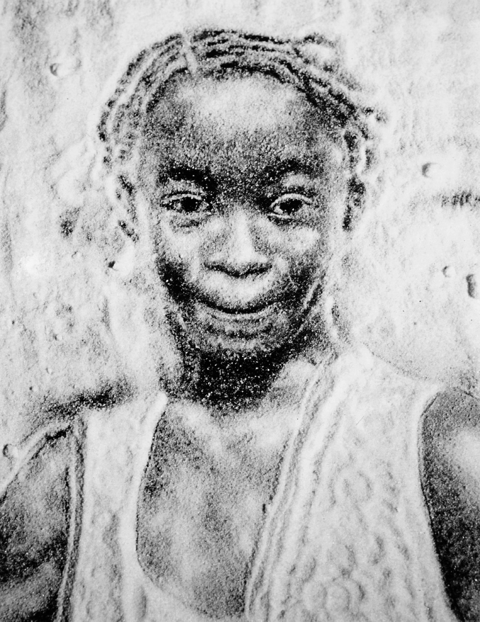 Imagem: Pintura em preto e branco composta por grãos em tons de preto. Rosto de uma jovem com tranças, olhos grandes, nariz largo e lábios finos.  Fim da imagem.