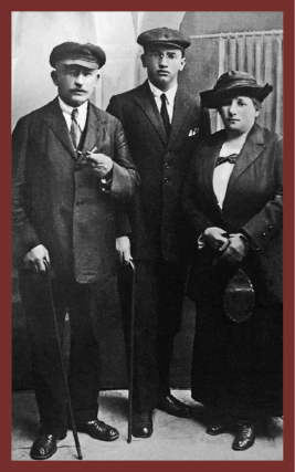 Imagem: Infográfico. Na parte inferior, mapa-múndi com destaque para o Brasil (laranja), M. H. Vieira da Silva - Portugal (vermelho), Lina Bo Bardi - Itália (verde). Lasar Segall - Lituânia (azul), Samson Flexor - Romênia (marrom), Manabu Mabe - Japão (verde-escuro). Abaixo, a rosa dos ventos e a escala. Em volta, fotografias em preto e branco com bordas coloridas:  1) Vermelho - Foto de uma criança com chapéu, vestido e sapatos em pé.  2) Verde - Foto de mulher sorrindo e segurando um navio sobre a cabeça. 3) Azul - Foto de um casal sentado. Entre eles há duas crianças e atrás, três jovens.  4) Marrom - Foto de um homem e um jovem com ternos e uma mulher com chapéu.  5) Verde-escuro - Foto de uma mulher oriental sentada. Em volta dela há cinco crianças e ao lado, um homem oriental está em pé.  Fim da imagem.