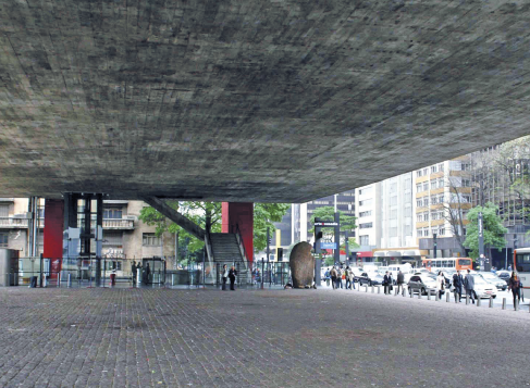 Imagem: Fotografia. Um espaço amplo embaixo do Masp. Ao fundo, as duas colunas vermelhas e prédios. Fim da imagem.