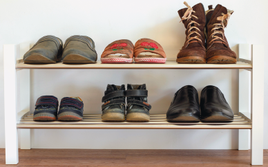 Imagem: Fotografia. Estante aberta com quatro vigas apoiando duas prateleiras com seis pares de sapatos alinhados.  Fim da imagem.
