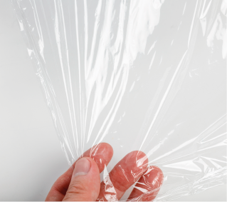 Imagem: Fotografia. Destaque de uma mão segurando uma folha transparente resistente. Fim da imagem.