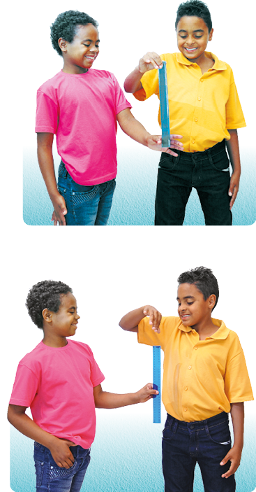 Imagem: Fotografia. Menino de cabelo curto preto cacheado, vestindo camiseta rosa e calça azul. Está segurando uma régua junto com um menino de cabelo curto preto, vestindo camiseta amarela e calça preta.  Fotografia. Menino de cabelo curto preto cacheado, vestindo camiseta rosa e calça azul. Está segurando uma régua sobre o tronco de um menino de cabelo curto preto, vestindo camiseta amarela e calça preta.   Fim da imagem.