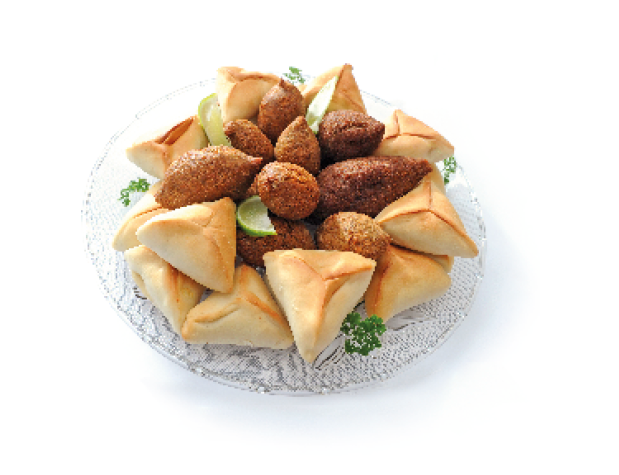 Imagem: Fotografia. Prato com quibes e esfihas em cima.  Fim da imagem.