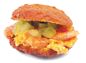 Imagem: Fotografia. Um acarajé recheado.   Fim da imagem.