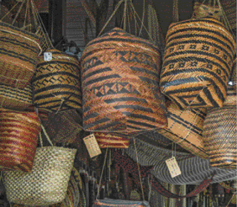 Imagem: Fotografia. Cestos coloridos de palha estão pendurados.   Fim da imagem.