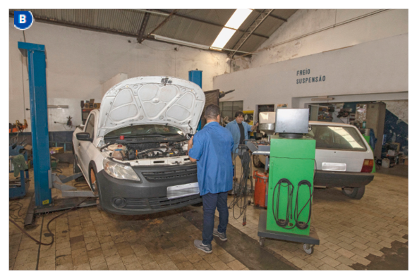 Imagem: Fotografia B. Dois homens estão ao lado de carros com os capôs abertos.  Fim da imagem.
