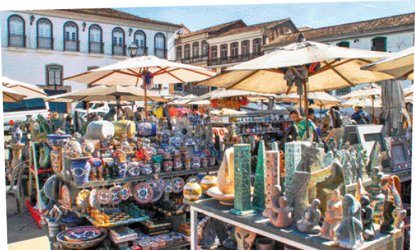 Imagem: Objetos de rochas esculpidas. Em diversas localidades da Região Sudeste, vários artesãos produzem vasos, potes, gamelas, caixas e esculturas esculpindo rochas. Região Nordeste: um chapéu, um boi e um cacto. Seta para fotografia com o destaque da mão de uma pessoa bordando uma flor. Renda de bilro confeccionada por artesã no município de Aquiraz, no estado do Ceará, em 2018.  Fim da imagem.