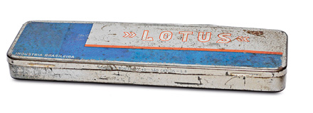 Imagem: Fotografia. Um estojo metálico de cor prata e azul. Fim da imagem.