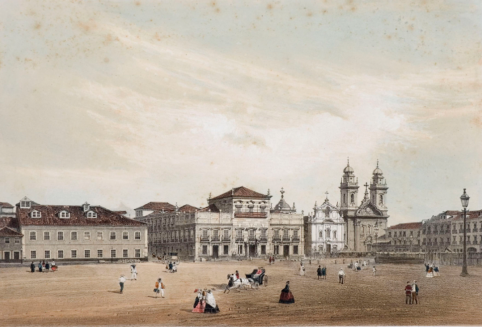 Imagem: Litografia. Um amplo espaço aberto por onde passam pessoas, algumas sozinhas e outras em grupo. A maioria está a pé e há uma carruagem. As mulheres usam longos vestidos rodados e chapéu e os homens usam calças, camisas e chapéu. Ao redor, fachadas de amplos prédios com muitas janelas e portas amplas. Também há uma igreja com bastante destaque com duas torres e o crucifixo ao centro.  Fim da imagem.