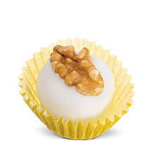 Imagem: Fotografia. Em uma forminha, um pequeno doce de aspecto liso, redondo branco com uma castanha no topo.  Fim da imagem.