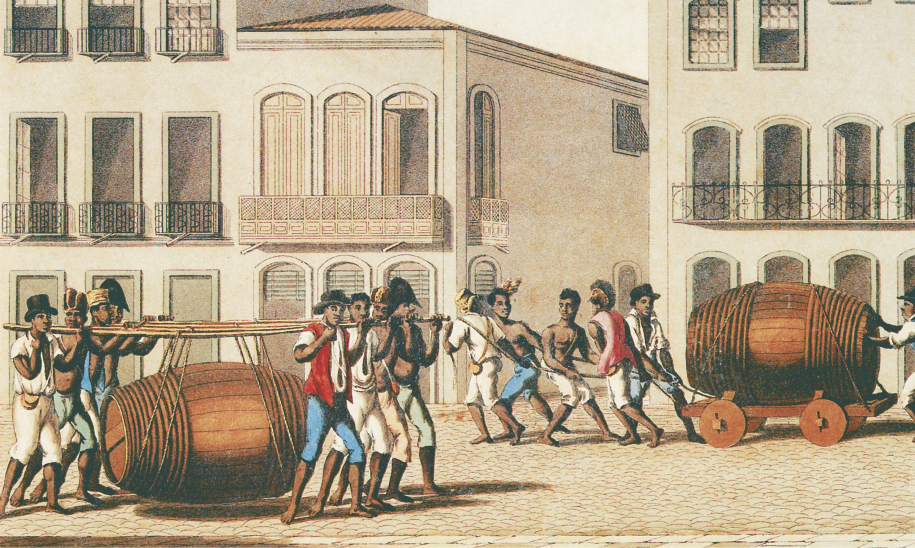 Imagem: Pintura. Em um espaço urbano aberto, dois grupos de homens descalços trabalham carregando cargas, alguns estão sem camisa, outros usam chapéus. Do lado esquerdo, oito rapazes se dividem em duas fileiras frente a frente e carregam vigas de madeira nos ombros nas quais estão amarradas cordas presas a um grande barril. Do lado direito, ao fundo, outro grande barril é transportado deitado sobre uma estrutura com rodas e empurrado atrás por um homem e puxado na frente por cordas por outros cinco rapazes. Ao redor, há construções assobradadas com muitas janelas grandes e sacadas.  Fim da imagem.